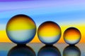 Three glass crystal balls in a row with a rainbow of colorful light painting behind them Royalty Free Stock Photo