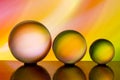 Three glass crystal balls in a row with a rainbow of colorful light painting behind them Royalty Free Stock Photo