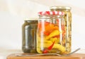 Three glass jars with canned peppers, olives, cucumbers Royalty Free Stock Photo