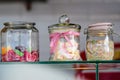 Three glass jars with colorful sugar sweets - candies, marshmallows and sprinkles, used to decorate ice cream and desserts display