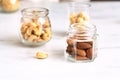 Three glass jars with different peeled nuts almonds, cashews, hazelnuts stand on a white table. Royalty Free Stock Photo