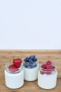 Three glass jars with yogurt and forest berries. Royalty Free Stock Photo