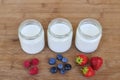 Three glass jars with yogurt and variation of berries. Royalty Free Stock Photo