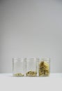 Three glass mason jars with gold coins. Royalty Free Stock Photo