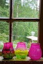Three glass mugs for candles in front of window