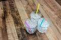 Three glass of tube ice with different color straws on wooden table from high angle. Royalty Free Stock Photo