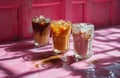 three glasses of coffees in a pink background