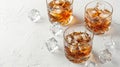 Three glasses of whiskey with ice on a white surface