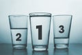 three glasses with different amount of water and rank numbers like medals podium - conceptual style