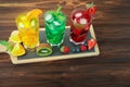 Three glasses of different cold summer drinks or refreshing cocktails yellow, green, red in toxic colors. Royalty Free Stock Photo