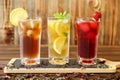 Three glasses of different cold tea drinks black, green with lemon and mint, hibiscus teas. Royalty Free Stock Photo