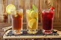 Three glasses of different cold tea drinks black, green with lemon and mint, hibiscus teas. Royalty Free Stock Photo