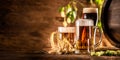 Three glasses with draft beer in front of a wooden barrel. Decoration of barley ears and fresh hops Royalty Free Stock Photo