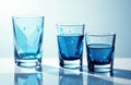 Three glasses filled with blue liquid are arranged in a row on a reflective Royalty Free Stock Photo