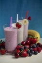 Three glasses of fresh fruit smoothie milkshake with berries and bananas