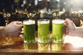 Three glasses of green beer on bar