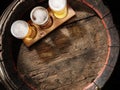 Three glasses of lager beer on old wooden barrel. Flat layer