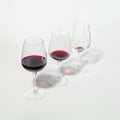 Three glasses with lowering levels of red wine poured, isolated on white. Mindful drinking and alcohol cutback Royalty Free Stock Photo