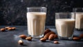 Three glasses of milk with almonds on a table