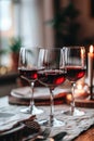 Three glasses of red wine on a dining table with candles Royalty Free Stock Photo