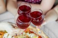 Three glasses of red wine in female hands. Toast at a party. Concept of alcohol, holiday