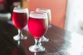 Three glasses with red wine on a wooden table. Glasses of cherry beer are on the table. There is no one in the frame Royalty Free Stock Photo