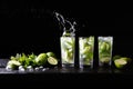 Three glasses of refreshing Mojito rum alcohol cocktail on the bar, splashes in a glass. Party cocktail. Lime, ice and Royalty Free Stock Photo