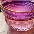 three glasses sitting on a wooden table next to a glass bowl