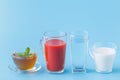 Three glasses with water, milk and juice closeup