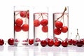 Three glasses of water and red cherries in the water on white background and cherries on the table. Concept of Hydration Royalty Free Stock Photo