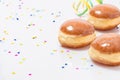 Three Glazed doughnuts with konfetti and streamers Royalty Free Stock Photo