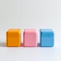 Three Glossy Cubes in Yellow Pink and Blue on White Seamless Background Royalty Free Stock Photo