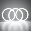 Three Glowing Interlocking Neon Rings on Reflective Surface Royalty Free Stock Photo