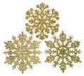 Three gold snowflake shape decorations isolated on white
