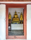 Three golden Buddha statue through the door Royalty Free Stock Photo