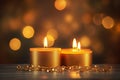 Three golden candles with bokeh backdrop