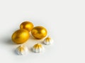 Three Golden Easter eggs and an airy meringue on a white background Royalty Free Stock Photo