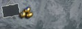 Three golden eggs with small chalkboard on dark shale background. Copy space Royalty Free Stock Photo