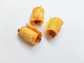 Three golden-fried, rolled spring rolls or savory snacks on a white background Royalty Free Stock Photo
