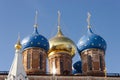 Three golden orthodox bright crosses are on top of blue and golden cupolas on the top of the stone church against blue dark sky Royalty Free Stock Photo