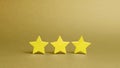 Three golden stars on a yellow background. Quality service, buyer choice. Success in business. The concept of rating Royalty Free Stock Photo