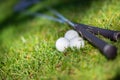 Three golf balls and golf clubs on green Royalty Free Stock Photo