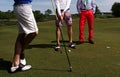 Three golf players on green field. Royalty Free Stock Photo