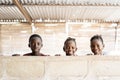 Three Gorgeous African Black Children Playing, Smiling and Laughing behind Wall