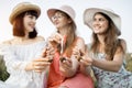 Three gorgeous female friends, enjoy picnic, showing delicious food, tasty roasted escargots