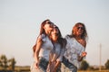 Three gorgeous young women in sunglasses dressed in the beautiful clothes are laughing outdoor on a sunny day. Royalty Free Stock Photo