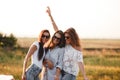 Three gorgeous young women in sunglasses stand in the field and smiling on a sunny day. Royalty Free Stock Photo