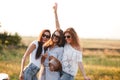 Three gorgeous young women in sunglasses stand in the field and smiling on a sunny day. Royalty Free Stock Photo