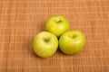 Three Granny Smith Apples on a Bamboo Placemat Royalty Free Stock Photo