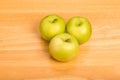 Three Granny Smith Apples on Wood Counter Royalty Free Stock Photo